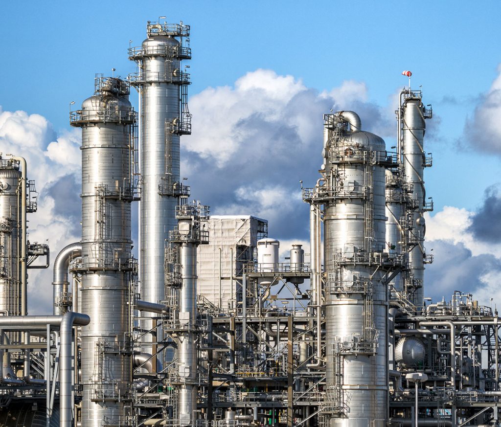 A 3D illustration of refinery columnsand other processing structures related to critical applications in the petrochemical processing industry. The diagram includes letters on elements of the illustration that correspond to applications that use spray nozzles and spray lances in their process, which are detailed in the image description
