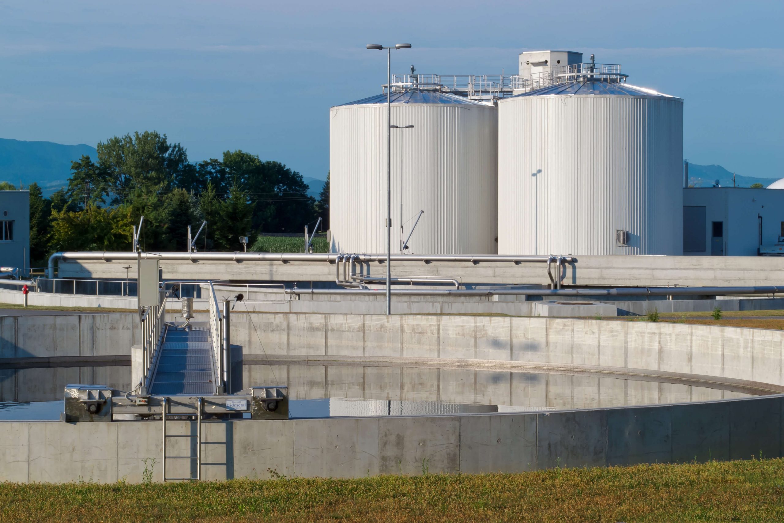 A photograph of air stripping towers for the wastewater industry with a holding pond in the foreground