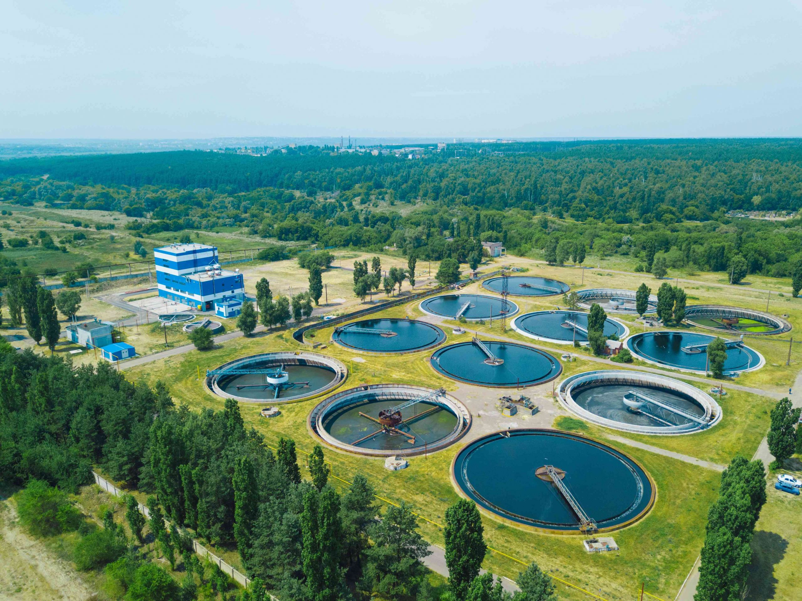 Detail of a modern wastewater and sewage treatment plant with aeration tanks and a walking platform over a holding pond.