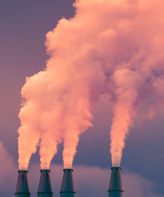 Smoke and steam rising into the air from power plant stacks.