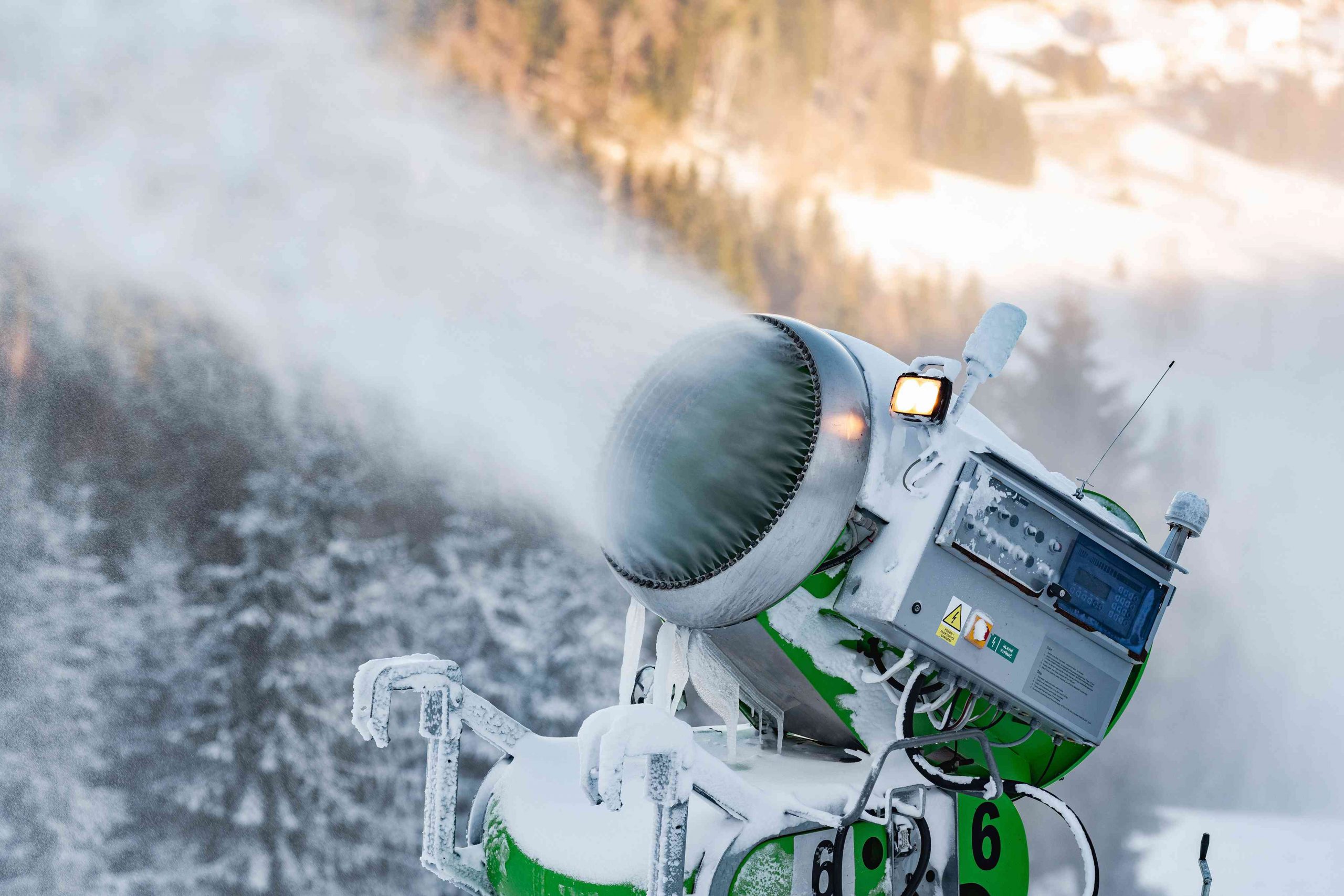 Snow cannon snowing on winter mountain.