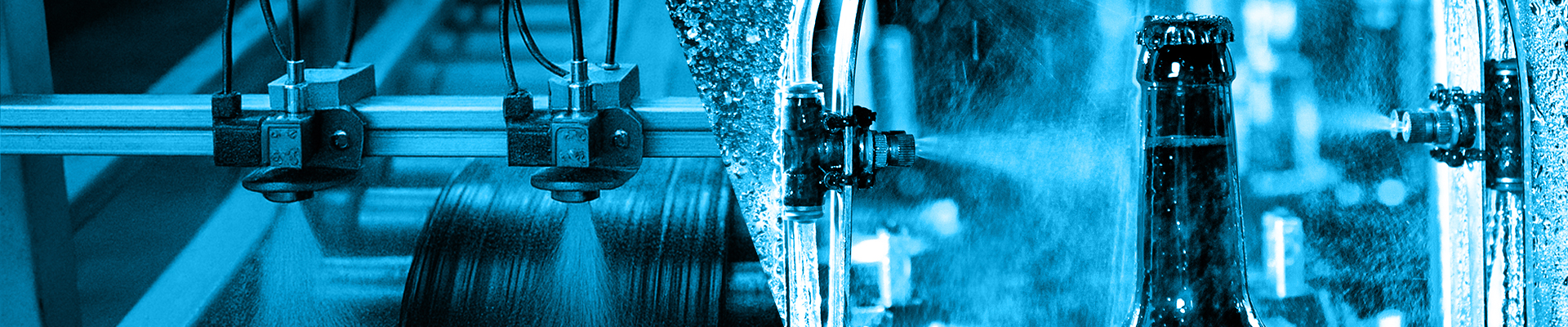 Detail of A bottle of beer on a conveyor belt under a stream of water. Only the bottle is in focus. The concept of production.
